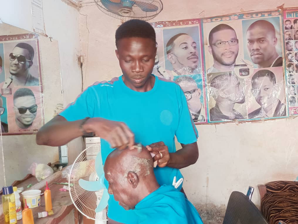 Yacouba Kaboré coiffant un client 